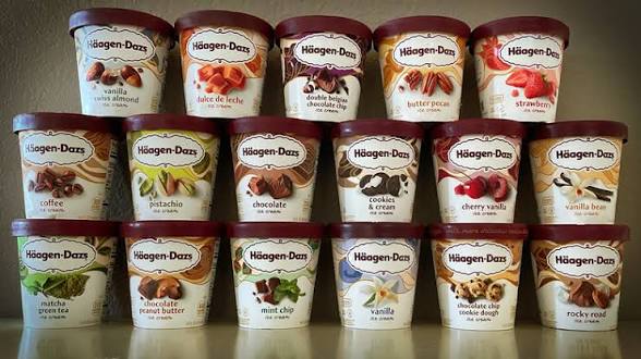 Various flavors of Häagen-Dazs ice cream in colorful tubs arranged neatly on a shelf.