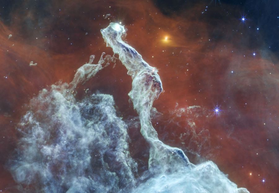 A colorful nebula with swirling clouds of gas and dust, featuring a prominent structure resembling a ghostly figure amongst the stars.